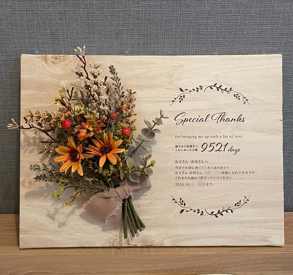 ナチュラルな木の温もりが感じられて、明るいオレンジカラーのスワッグが可愛い子育て感謝状