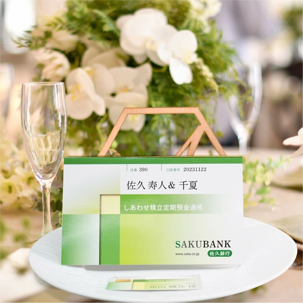 銀行の通帳がデザインされたサイズもそのままの型の結婚式プロフィール席次表とキャッシュカード風デザインの結婚式席札