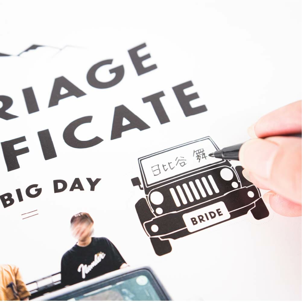 車の形をしたシールにゲストのサインとメッセージを書いてもらい仕上げる結婚証明書