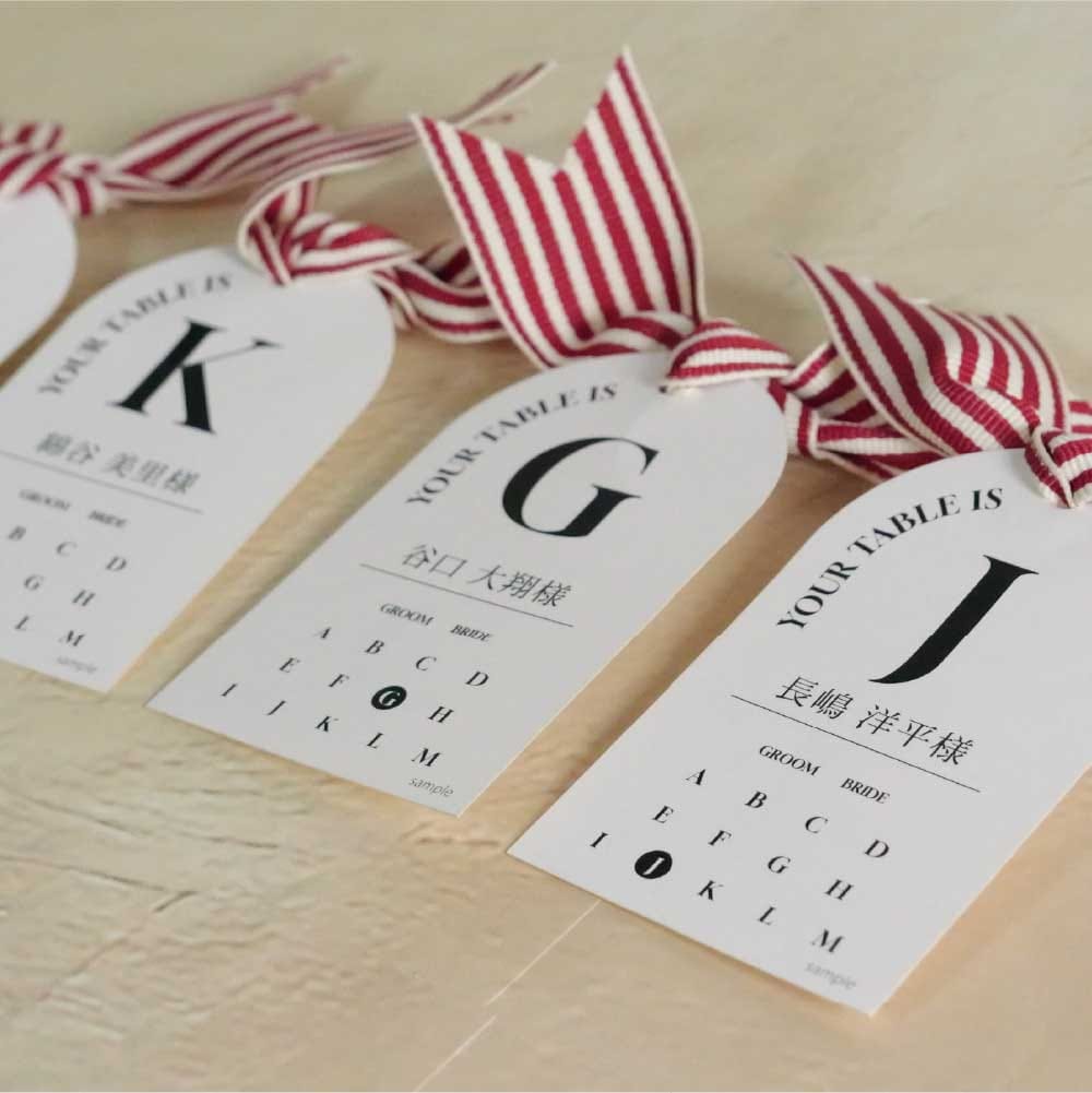 リボンで飾り付けた名刺サイズでアーチ形のテーブルレイアウト入りのエスコートカード