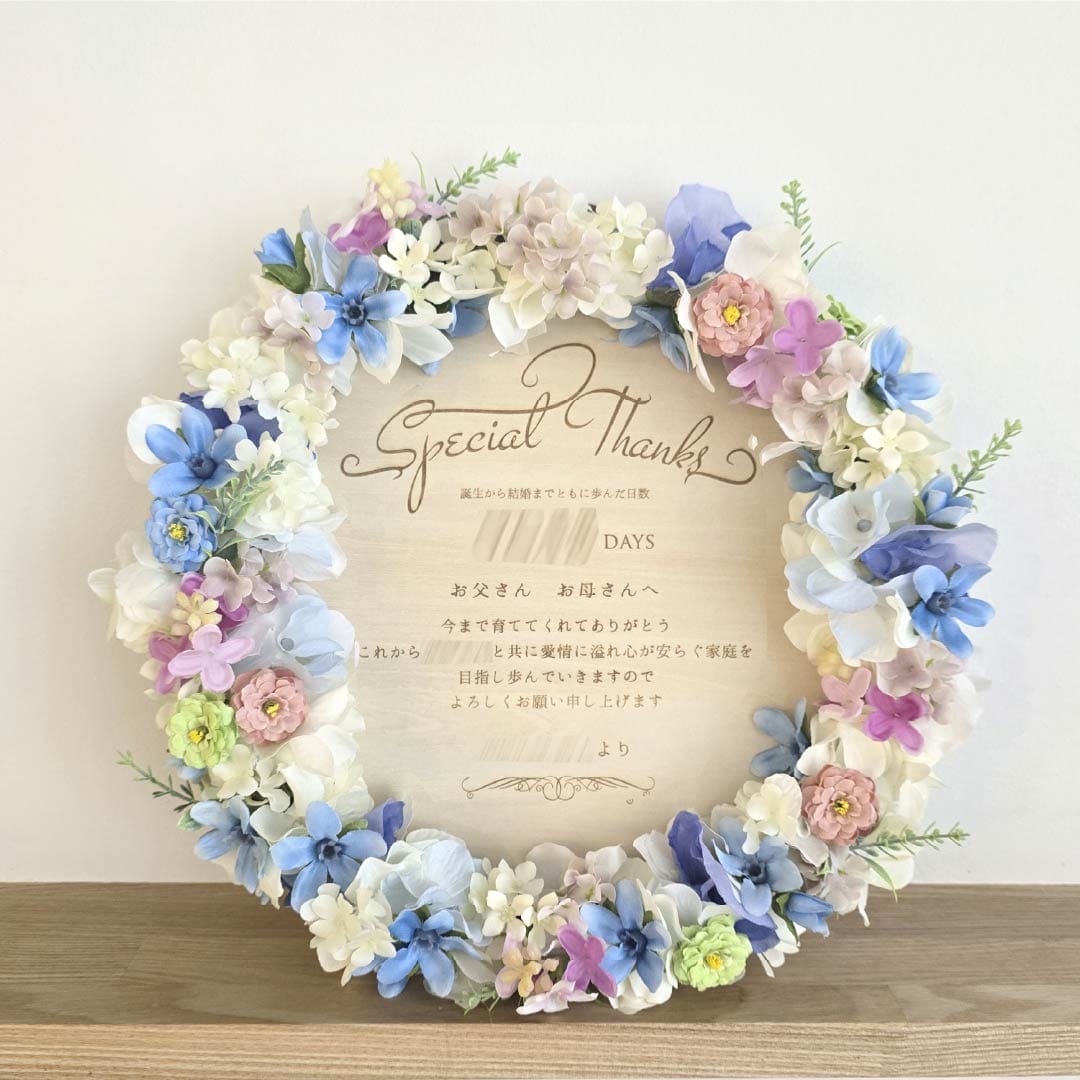 青を基調に、ピンクと白の花を添えたリース子育て感謝状