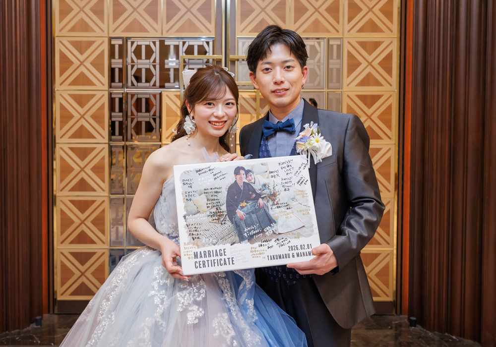 ゲストのサイン入りフォトキャンバスを持っている新郎新婦様
