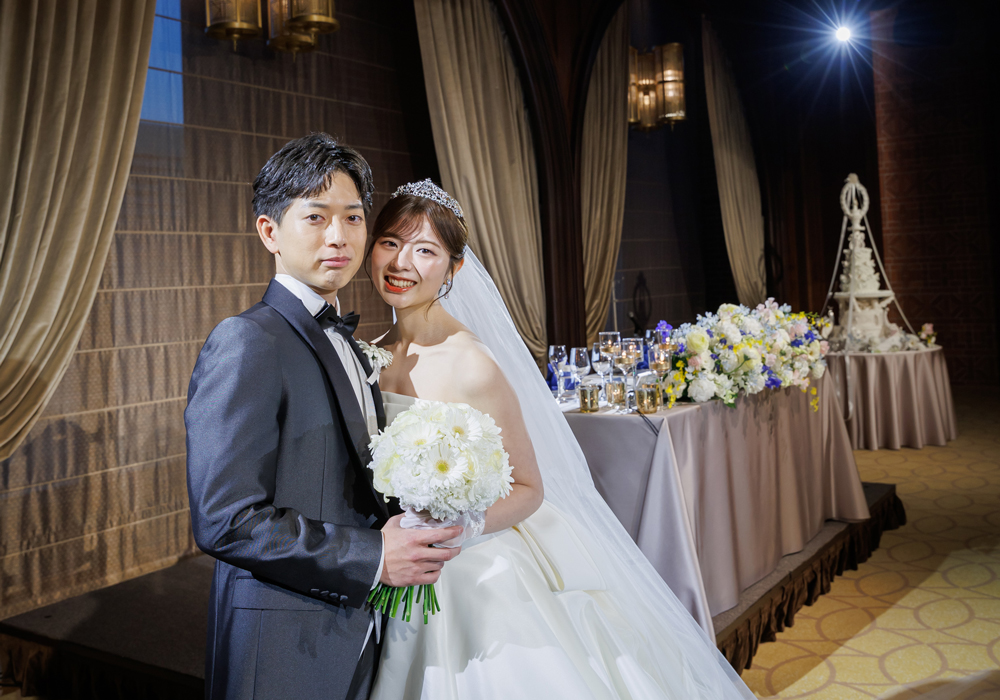 披露宴会場で寄り添う新郎新婦様