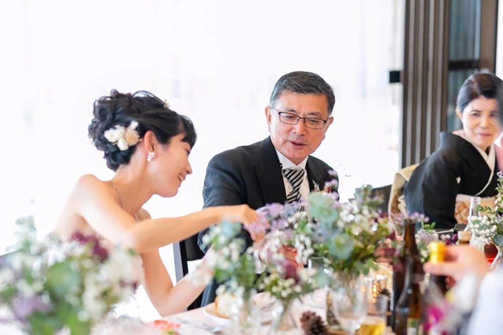結婚お披露目の両家食事会で歓談している花嫁と家族