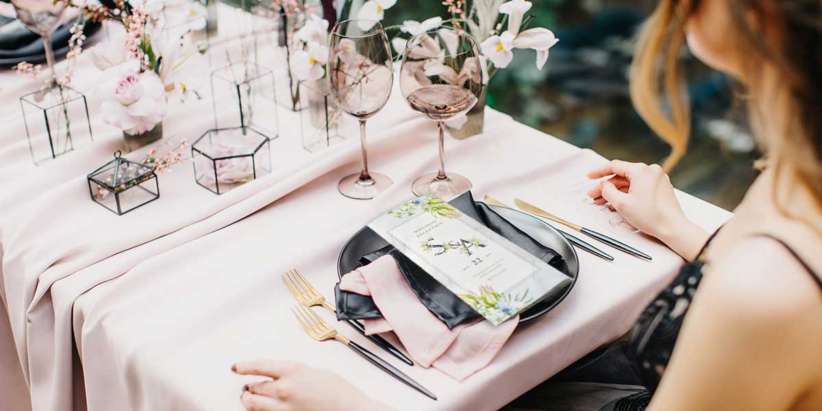 結婚式の披露宴に出席した女性のテーブルのお皿に席次表が置かれている