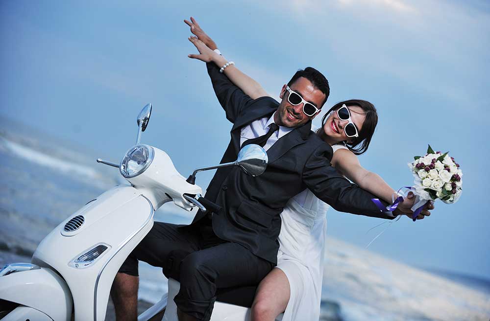 オートバイに乗ってポーズをとる新郎新婦