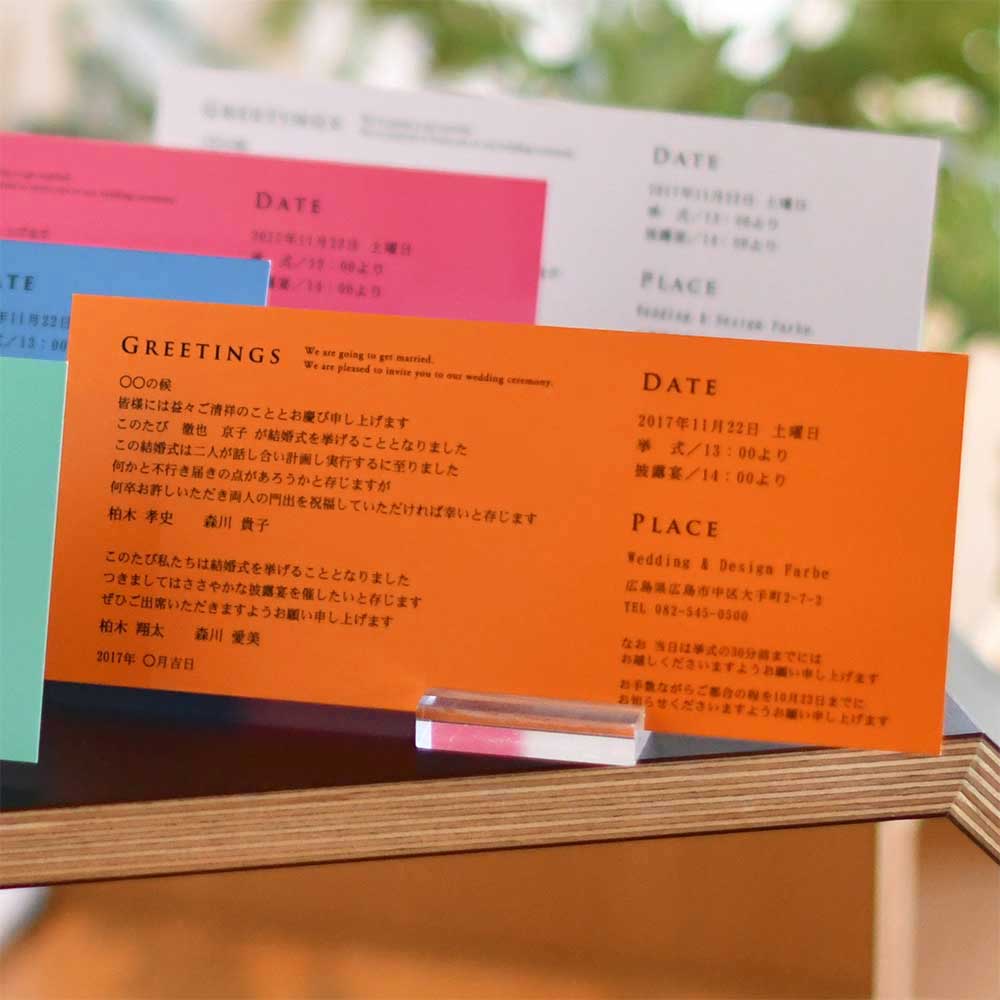 横長フォルムの台紙を開くと、トレーシングペーパーが本状に重ねられて。おふたりのイニシャル、挙式日入りのオリジナルな招待状