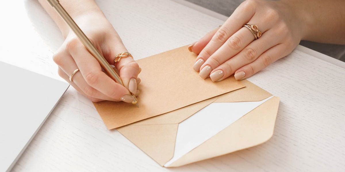 クラフト紙の便せんにメッセージを書こうとする様子