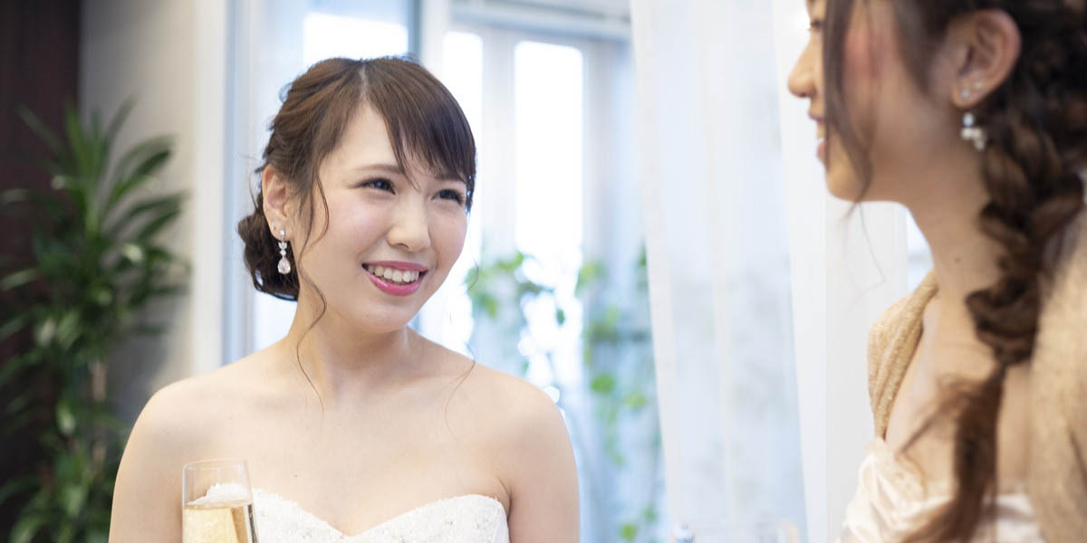 結婚式の披露宴で友人と話をする花嫁