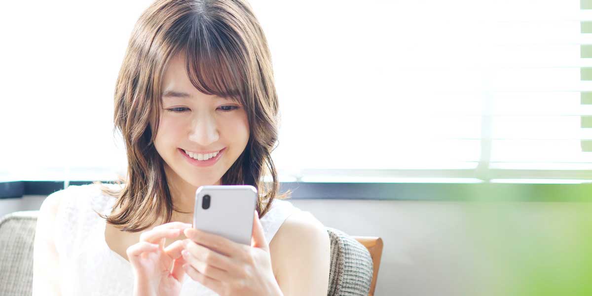 スマートフォンで問い合わせする女性