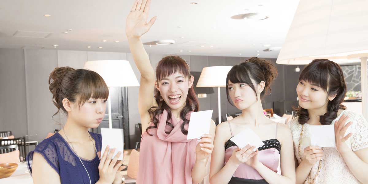 結婚式の演出のゲームで当たりが当たった女性と羨ましそうに見る友人