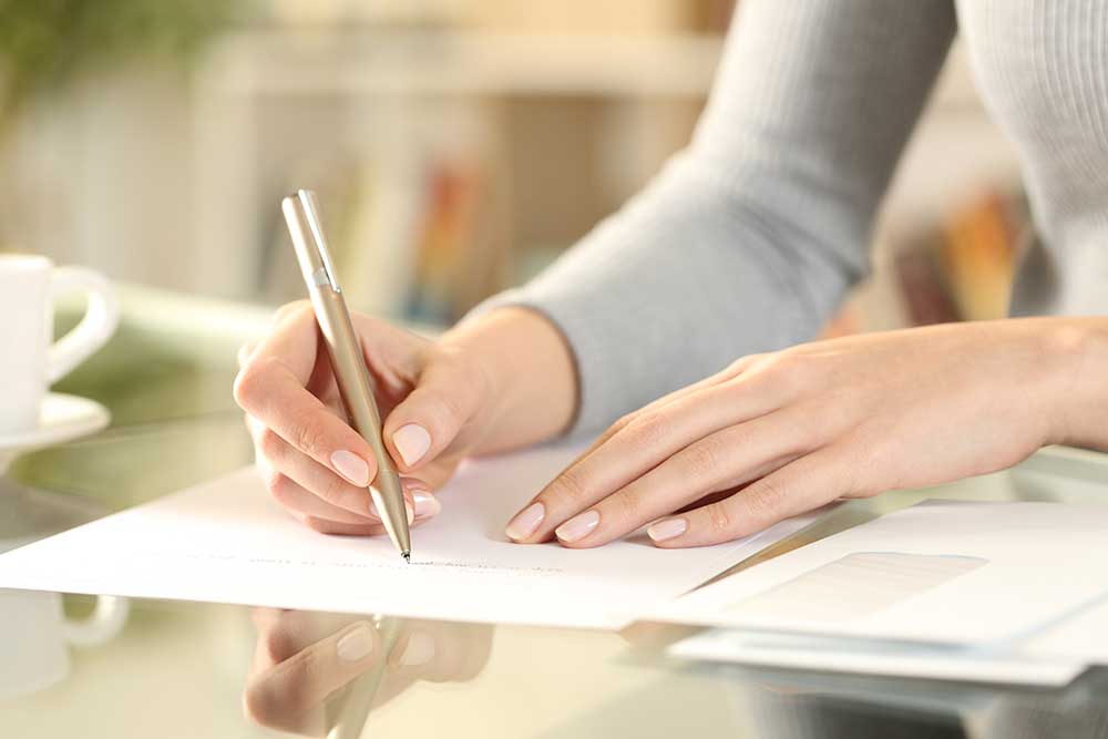 手紙を便箋に書く女性