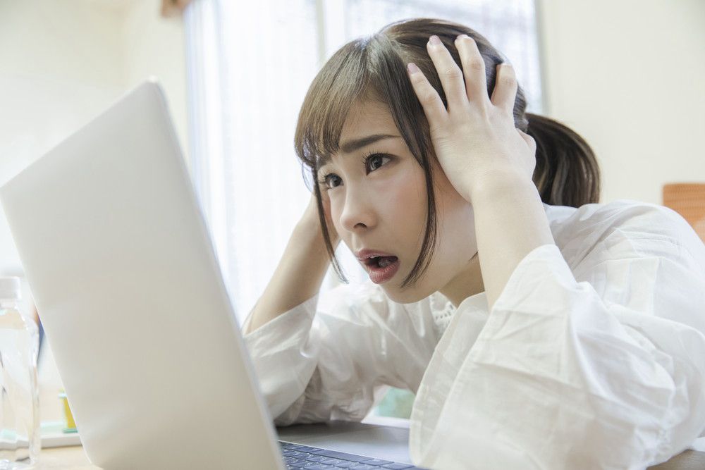 パソコンの前であたまを抱える女性