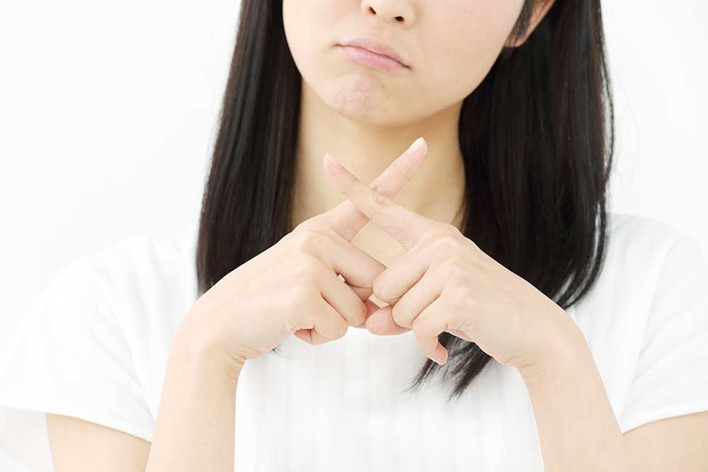 NGサインを作る女性