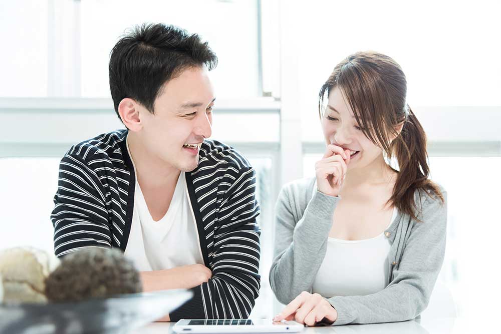 笑顔でタブレットを見ている男女カップル