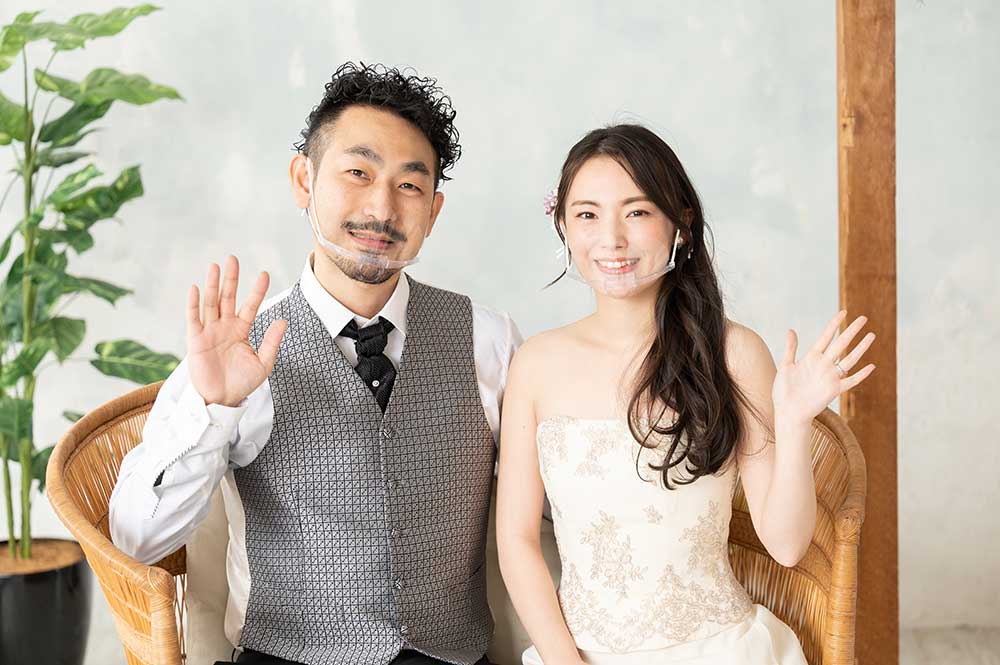 マウスシールドを付けた笑顔の新郎新婦