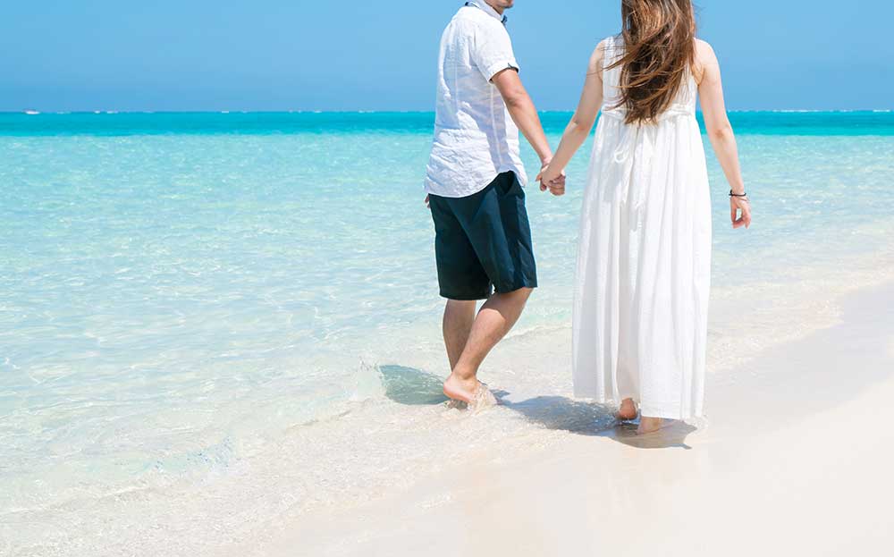 海辺を歩く新郎新婦