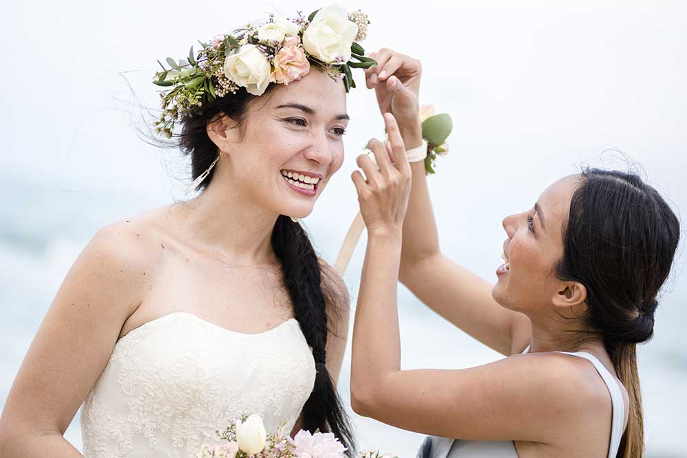 花嫁に花かんむりをつける姉妹