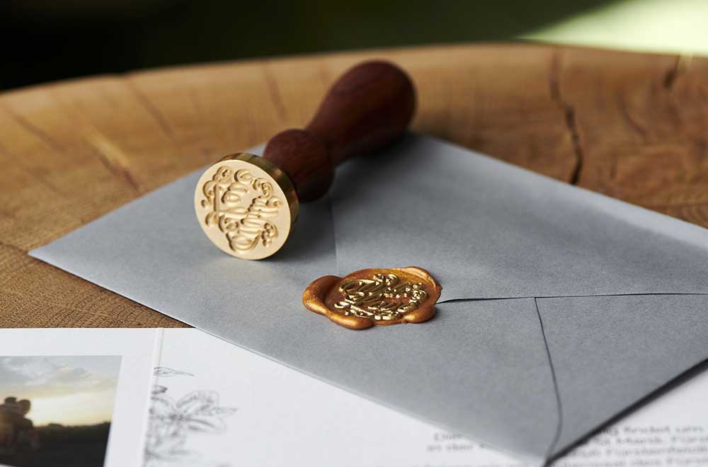 招待状の封筒にシーリングスタンプで封をする