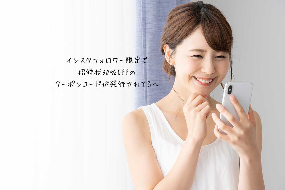 スマホを見て笑顔になる女性