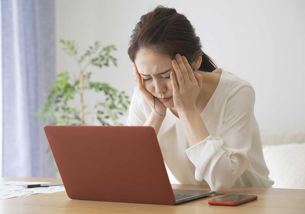 パソコンの前で頭をかかえている女性
