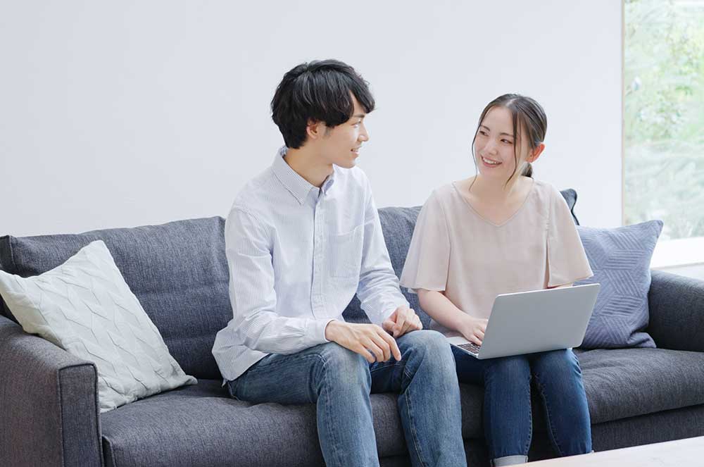 ソファで話をしている男女カップル