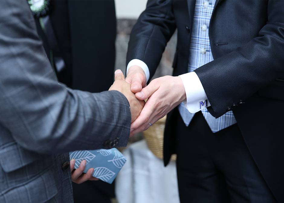 結婚式のお見送りで握手をしている新郎とゲスト