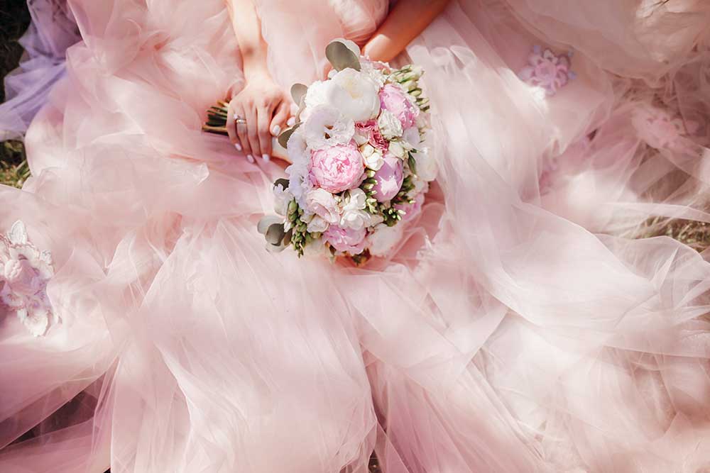 薄いピンクのドレスにピンクの花束を持った花嫁