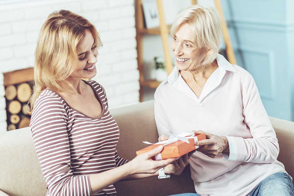 Elderly mother presenting a gift for her daughter