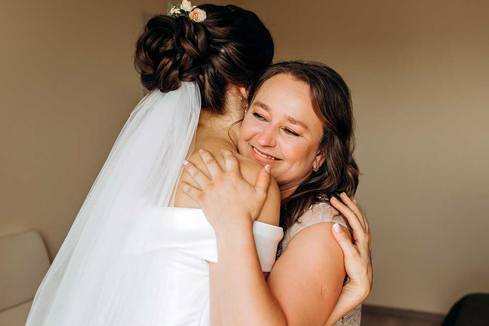 Sweet bride hugs her mom on her wedding day