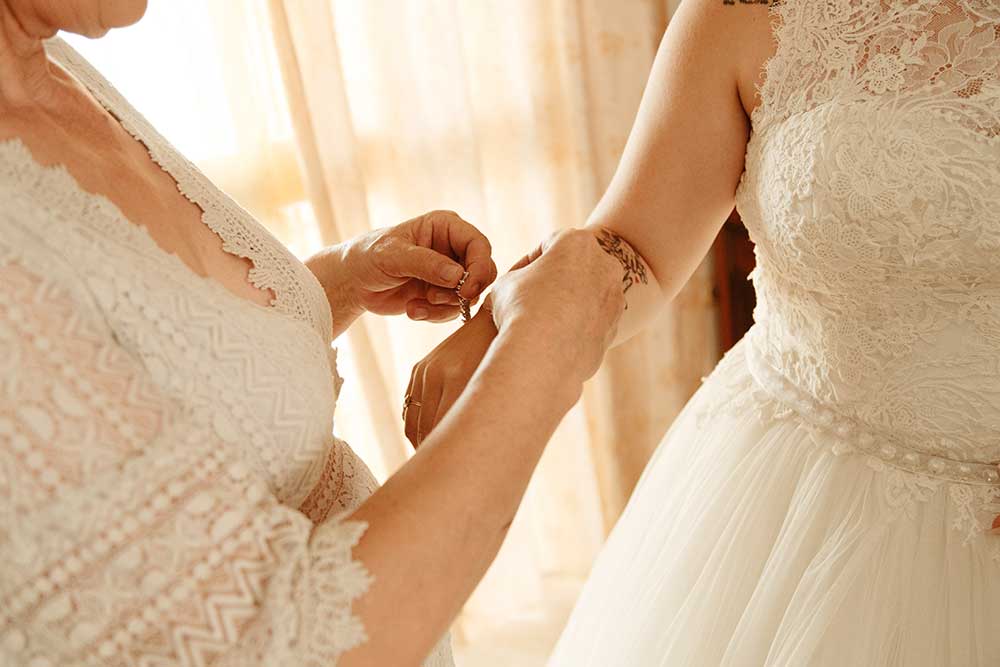 Mother of bride helping her daughter to get ready