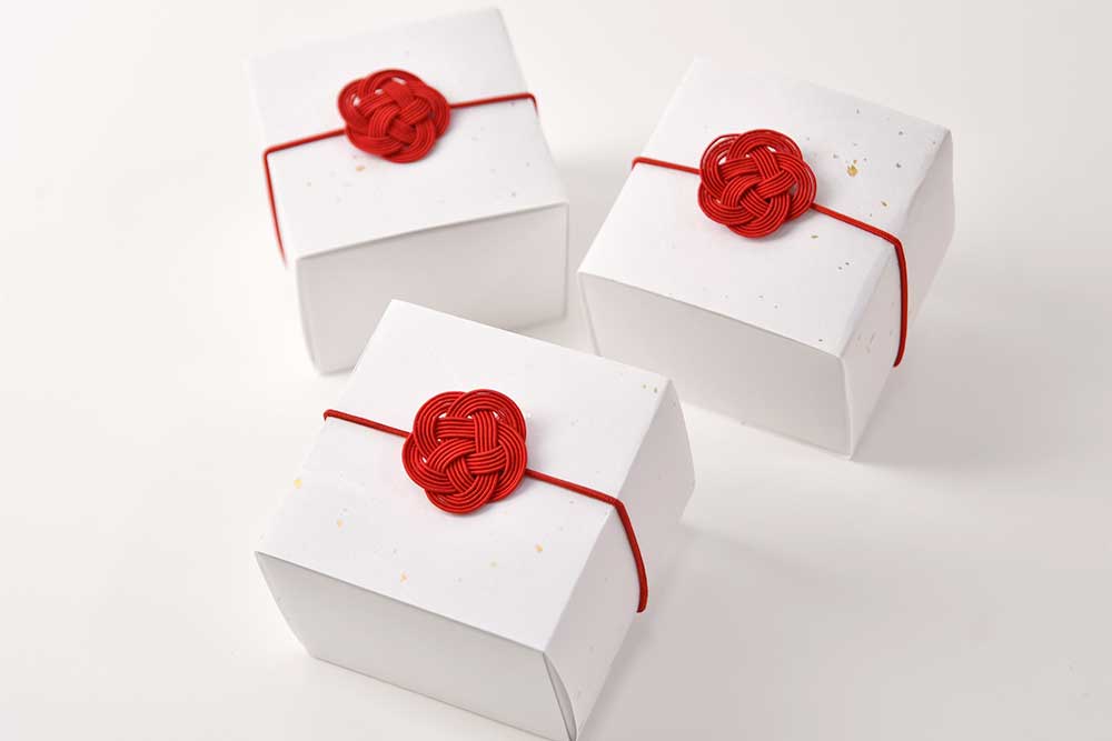 白箱に入れて朱色の梅結び付きラッピングをしてお届け