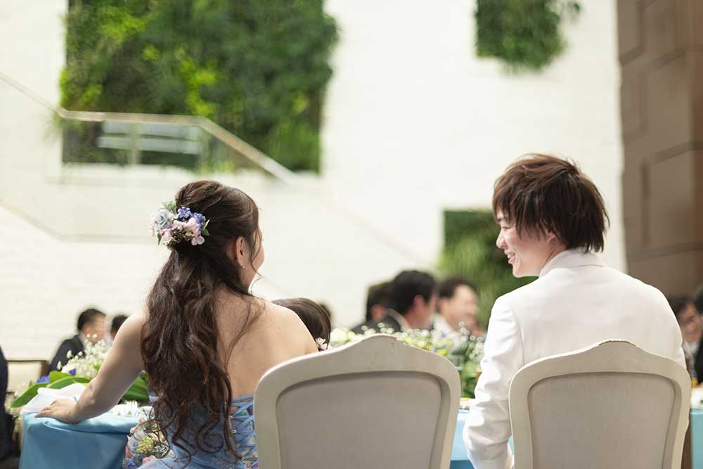 披露宴の高砂で笑顔で話す新郎新婦