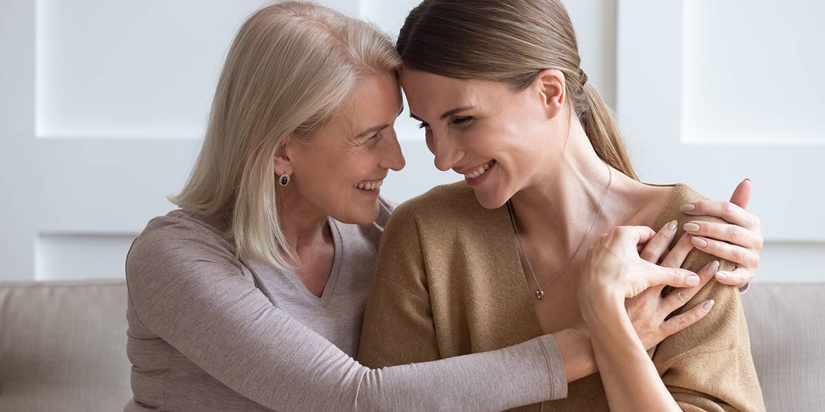 Happy mature mom and adult daughter hugging