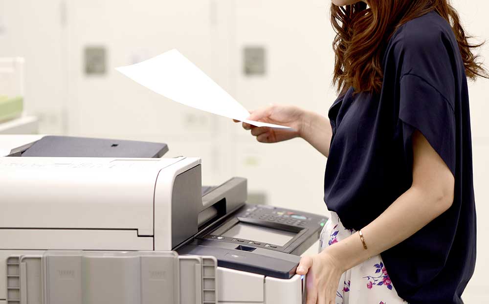 プリンタで印刷している女性