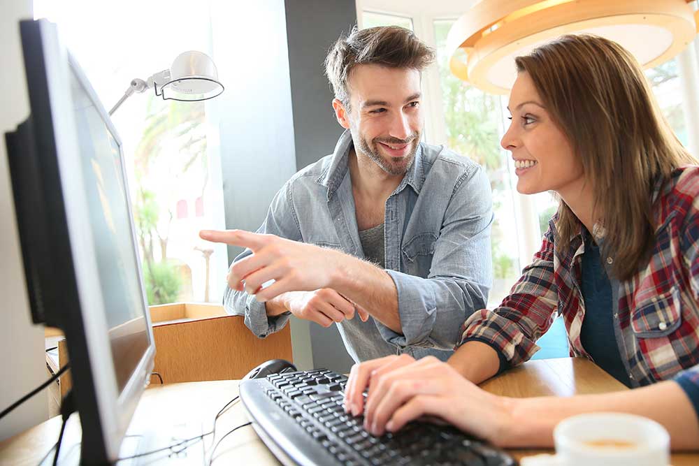 パソコンで仲良く作業をしているカップル