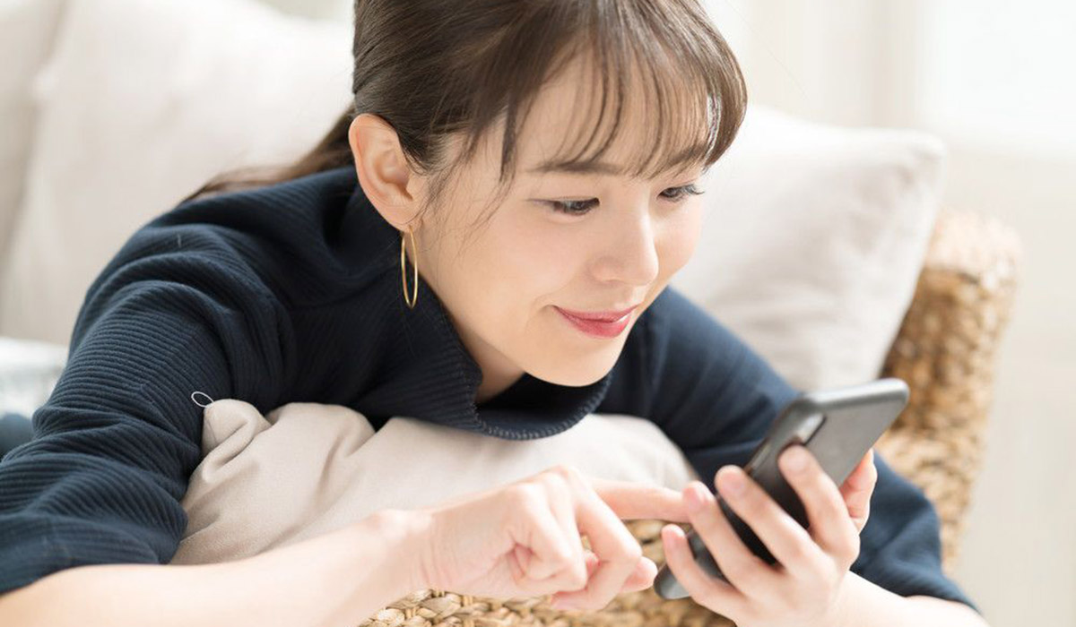 スマホを見ながら微笑む女性