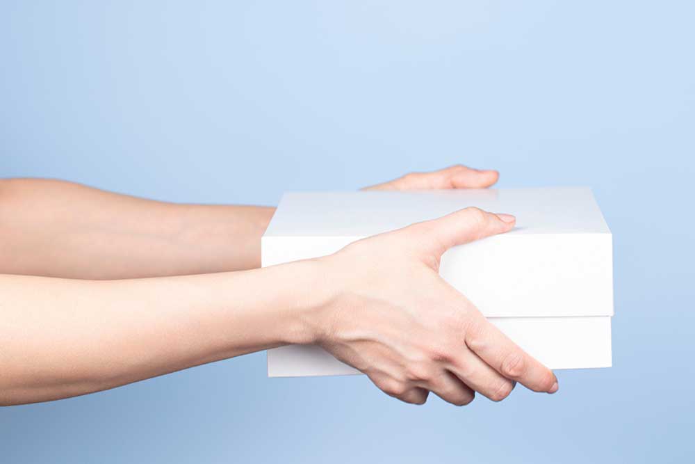 白い箱を両手で手渡している