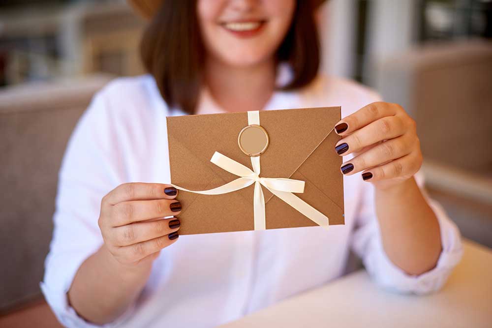 結婚式の招待状を手に持っている女性