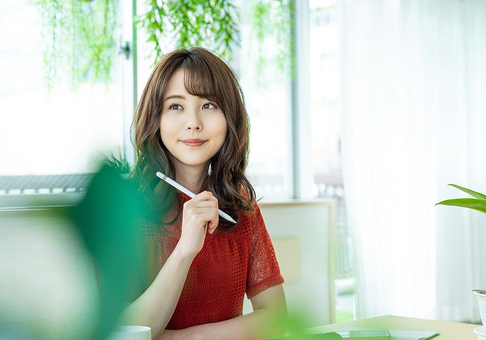 案内状について考えている女性