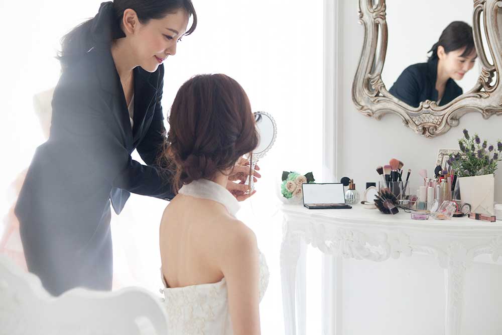 花嫁にヘアメイクをしている