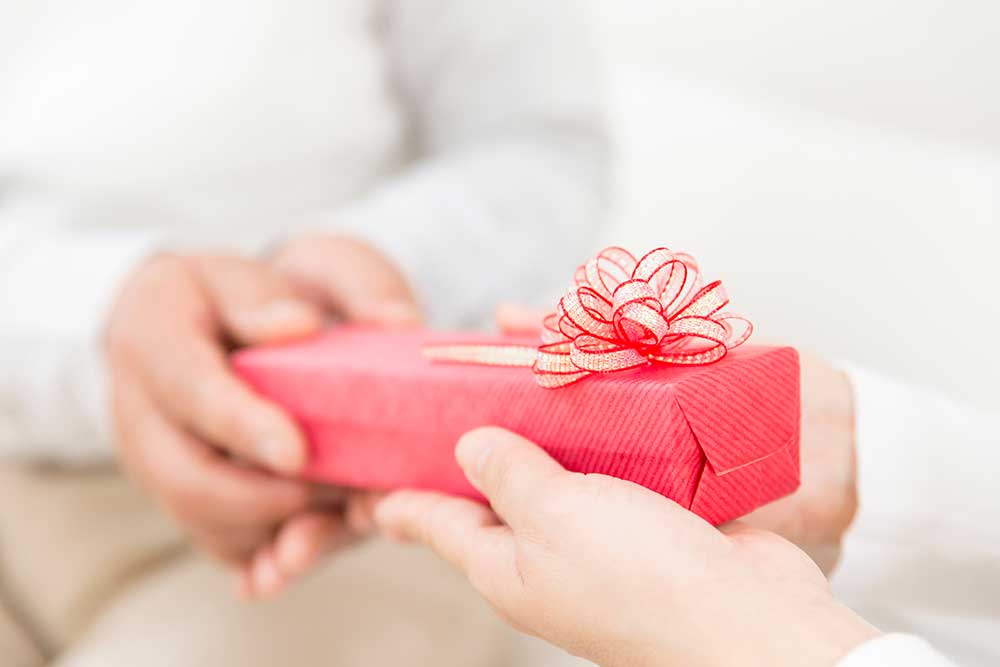 赤い包装紙でラッピングしたプレゼントを渡している