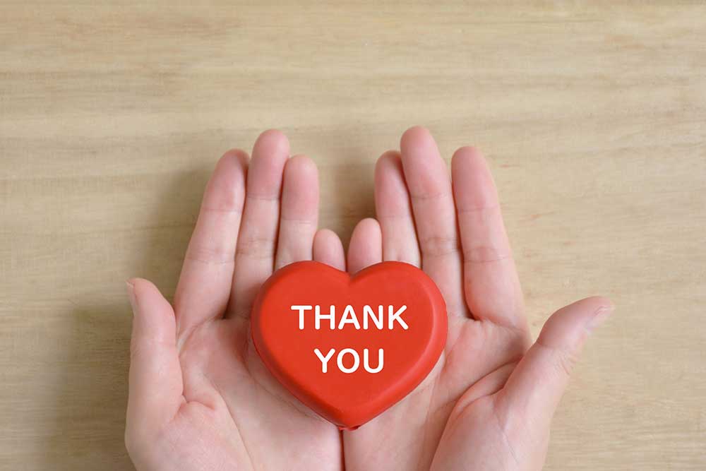 Thankyouと書いてある赤いハートを手のひらにのせている