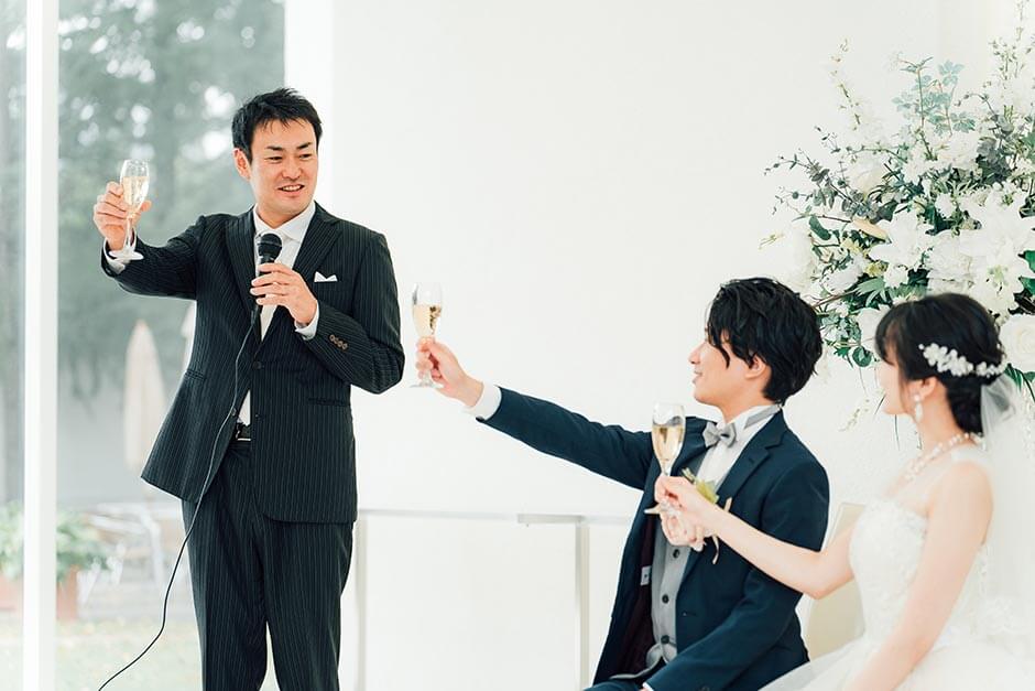 結婚式の披露宴で乾杯の挨拶をしている男性ゲスト