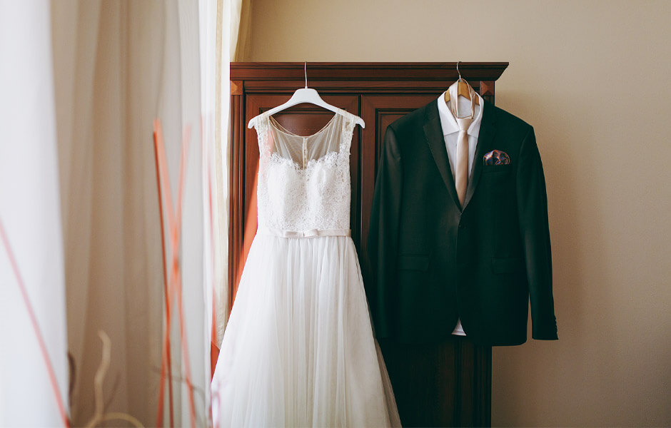 ウェディングドレスとタキシードを部屋に並べてかけてある