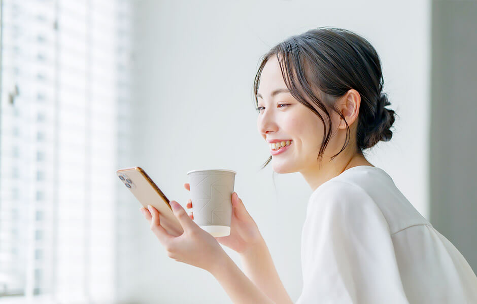 WEB招待状のプロフィールを見て微笑む女性