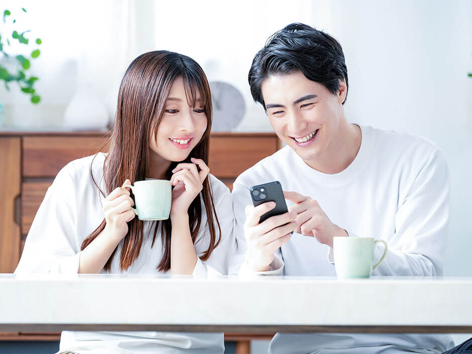 一緒にスマートフォンを見ているカップル