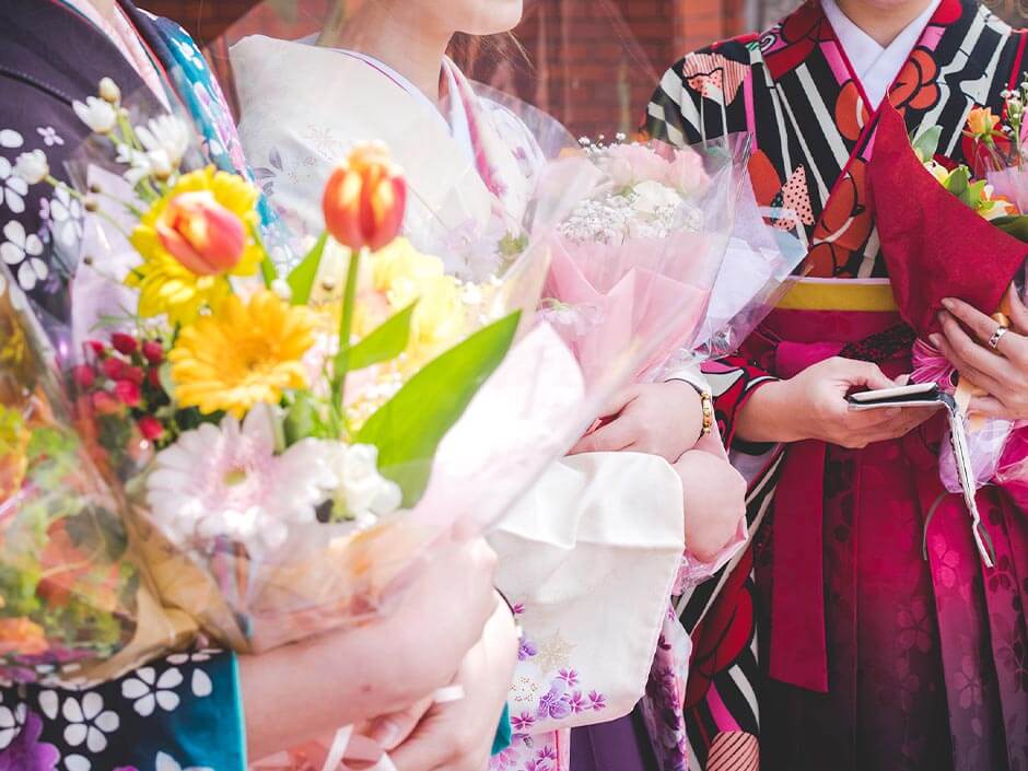 大学の卒業式で花束をもらった袴姿の女性