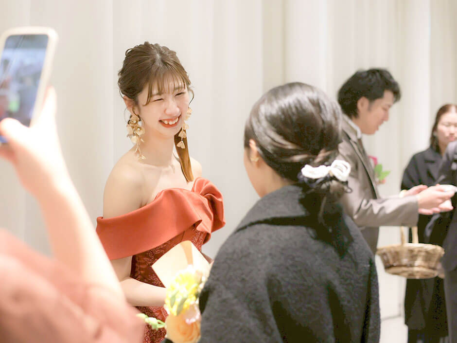 結婚式のお見送りでゲストにプチギフトを渡している新郎新婦