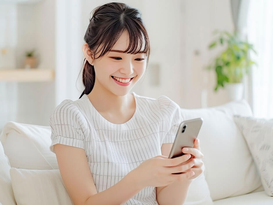 スマートフォンを見ている笑顔の女性